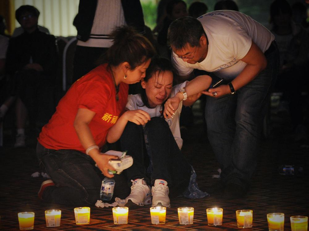 A woman reacts as Chinese relatives of passengers on the missing Malaysia Airlines Flight MH370 take part in a prayer service at the Metro Park Hotel in Beijing on April 8, 2014.