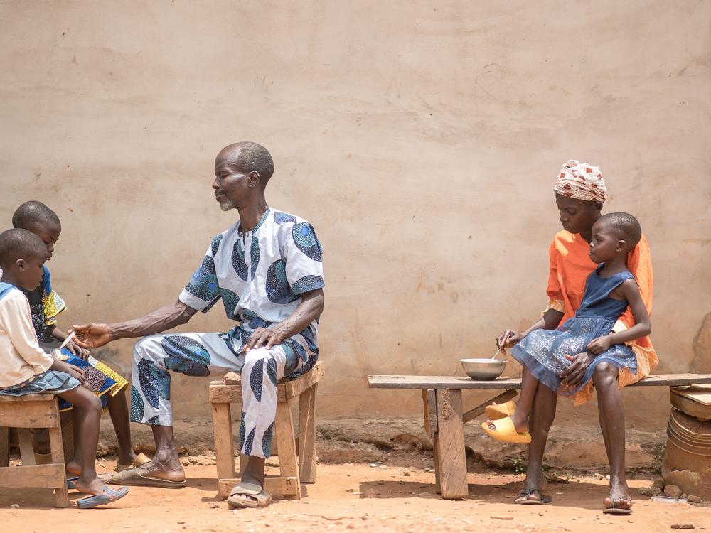 Toyin feeds her 3-year-old daughter, Kudirat, while her husband, Saheed, tends to their other two children.