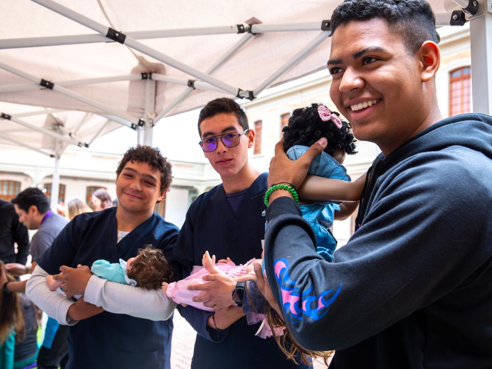 At a one-day workshop run by the Care School for Men in Bogotá, Colombia, male medical students at Sanitas University learn how to cradle a baby. This class of participants consists of medical students, but the usual enrollees are dads of all types.