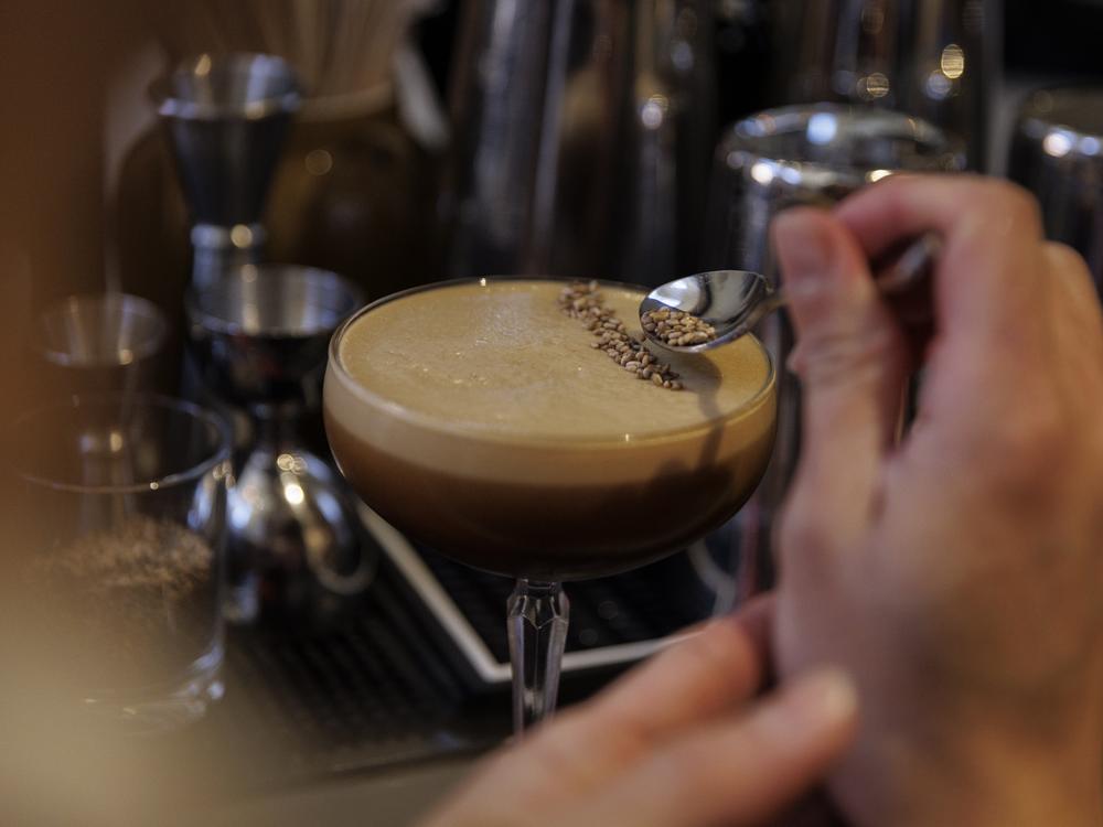 Daniel Gonzalez makes a café de olla at Providencia in Washington, D.C., on Dec. 12. This alcoholic cocktail contains rum, coffee, sesame and horchata and is served with a piece of packaged Kopiko coffee candy.