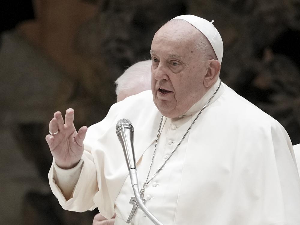 Pope Francis delivers his blessing as he exchanges season greetings with Vatican employees, in the Paul VI Hall at the Vatican, Saturday, Dec. 21, 2024.