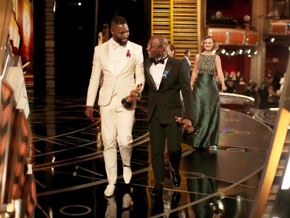 Screenwriter Tarell Alvin McCraney (left) and writer/director Barry Jenkins (right) accept the Best Adapted Screenplay award for 