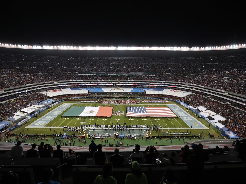 The flags of Mexico and the United States cover the field before an NFL football game between the Los Angeles Chargers and the Kansas City Chiefs Nov. 18, 2019, in Mexico City.