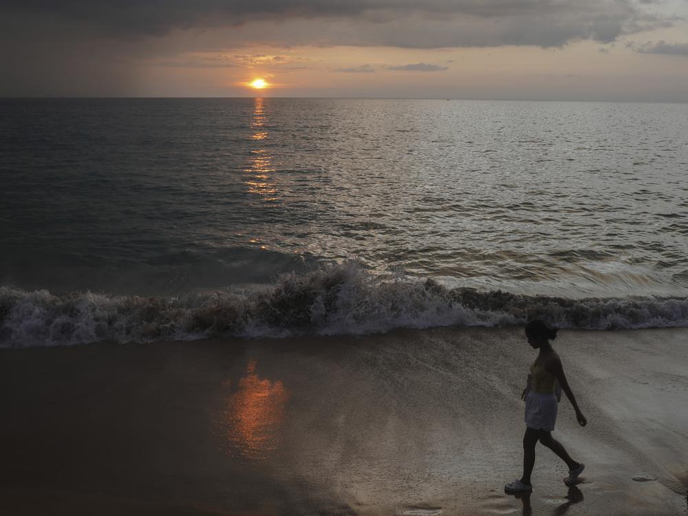 A woman walks on Bang Niang Beach, where tsunami hit 2004, Takuapa district of Phang Nga province, southern Thailand, Sunday, Dec. 8, 2024. (AP Photo/Sakchai Lalit)