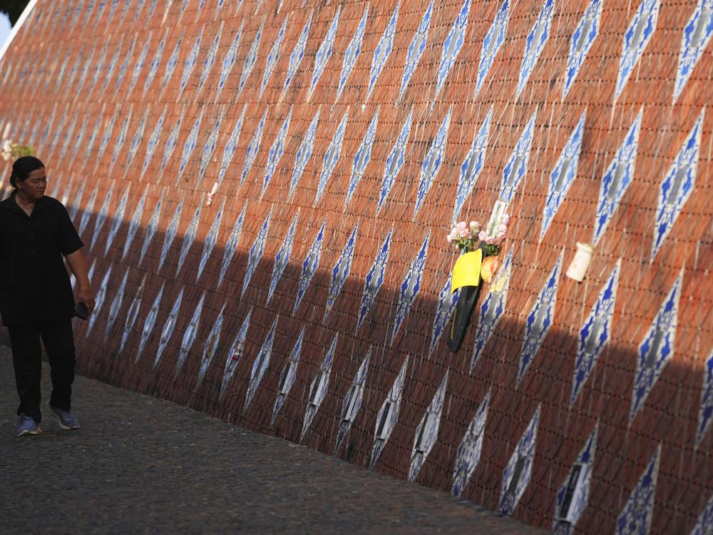 Visitors look at a tiled memorial wall displaying names of victims from the tsunami 2004 in Tsunami memorial park, at Ban Nam Khem, Takuapa district of Phang Nga province, southern Thailand.