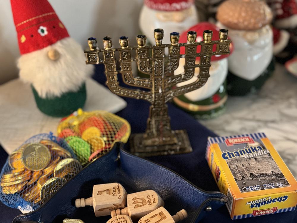 Coins, dreidels, a nine-branch menorah and candles adorn the sideboard at the Weiss-Pires' home in Oakland, Calif.