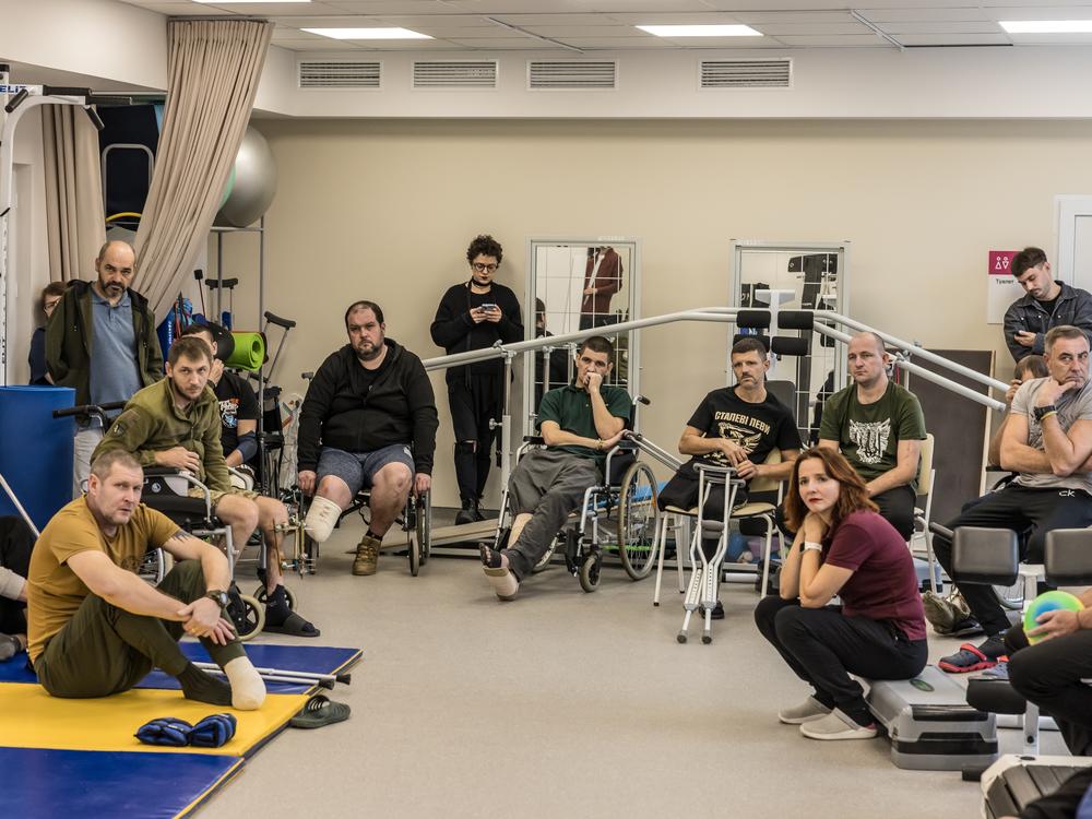 Injured soldiers at the Recovery rehabilitation center listen to Oleksandr Budko, a 28-year-old veteran, in Kyiv, Ukraine, on Oct. 18. During his visits to rehabs, soldiers ask Budko lots of practical questions about things like prosthetics and health care.