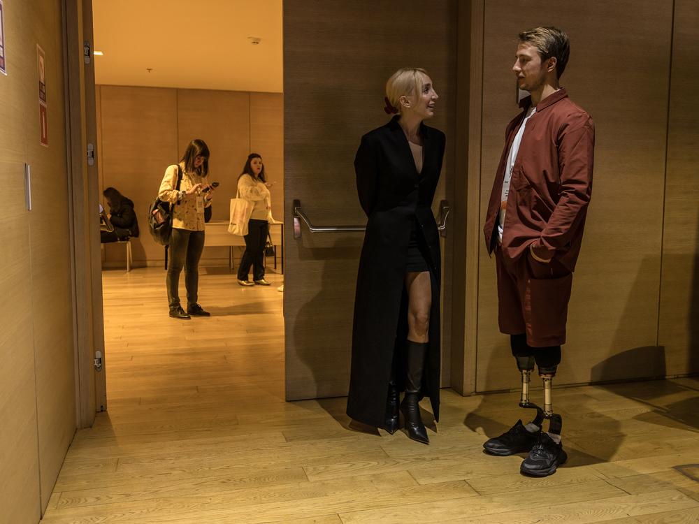 Oleksandr Budko talks to a participant at the Donbas Media Forum conference in Kyiv, Ukraine, on Oct. 18. Budko, a Ukrainian veteran who lost both legs on the front line, stars in the Ukrainian version of the TV show <em>The Bachelor</em>.