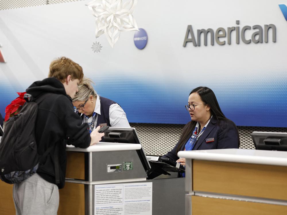 An American Airlines agent talks to a customer at O'Hare International Airport in Chicago, Ill., last week. On Tuesday, the airline issued a national halt to flights.