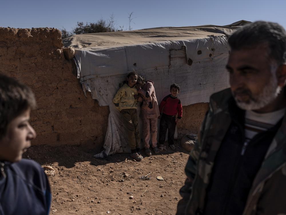 Displaced Syrian children and a man at the Rukban camp. More than 7,000 people have taken shelter there, many of them fleeing ISIS.
