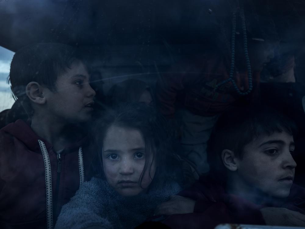 A group of Syrian children with their parents return home in the cabin of a truck, after more than eight years taking shelter in the Rukban camp for displaced people in al-Tanf, Syria, at the edge of the Jordanian border, Dec. 14.