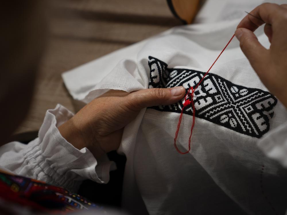 Hanna Haiduk uses a needle and thread to form intricate designs, many of which she copies from historical works she finds in books or those she saved from her family's past work.