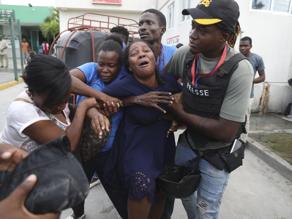 The wife of a journalist, who was shot during an armed gang attack on the General Hospital, cries as an ambulance arrives with his body, at a different hospital in Port-au-Prince, Haiti, on Tuesday.