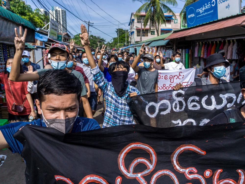 Protesters make the three-finger salute during a demonstration against the military coup in Yangon on May 15, 2021.