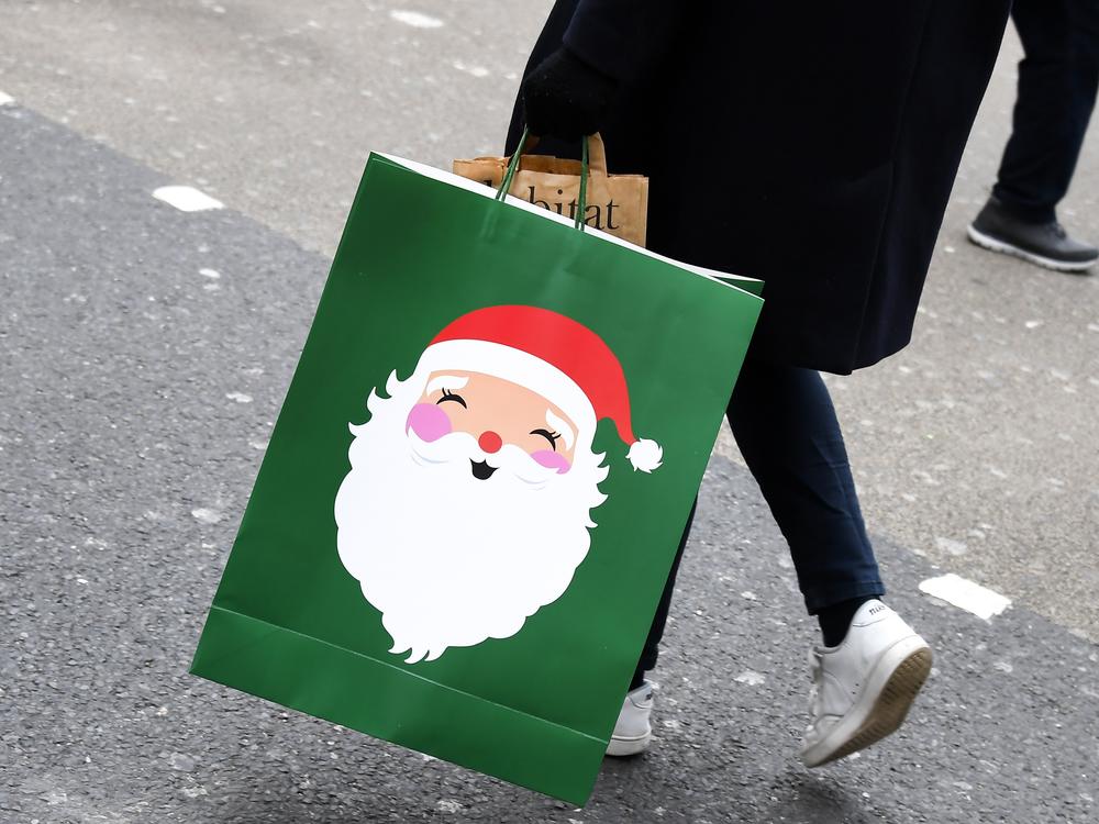 A shopper carries a Christmas-themed bag in London on Dec. 2, 2020.