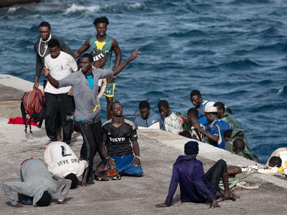 A group of migrants react to coming ashore after a boat from Senegal, with 85 migrant people on board, arrived at La Restinga port in the Canary Islands in August.
