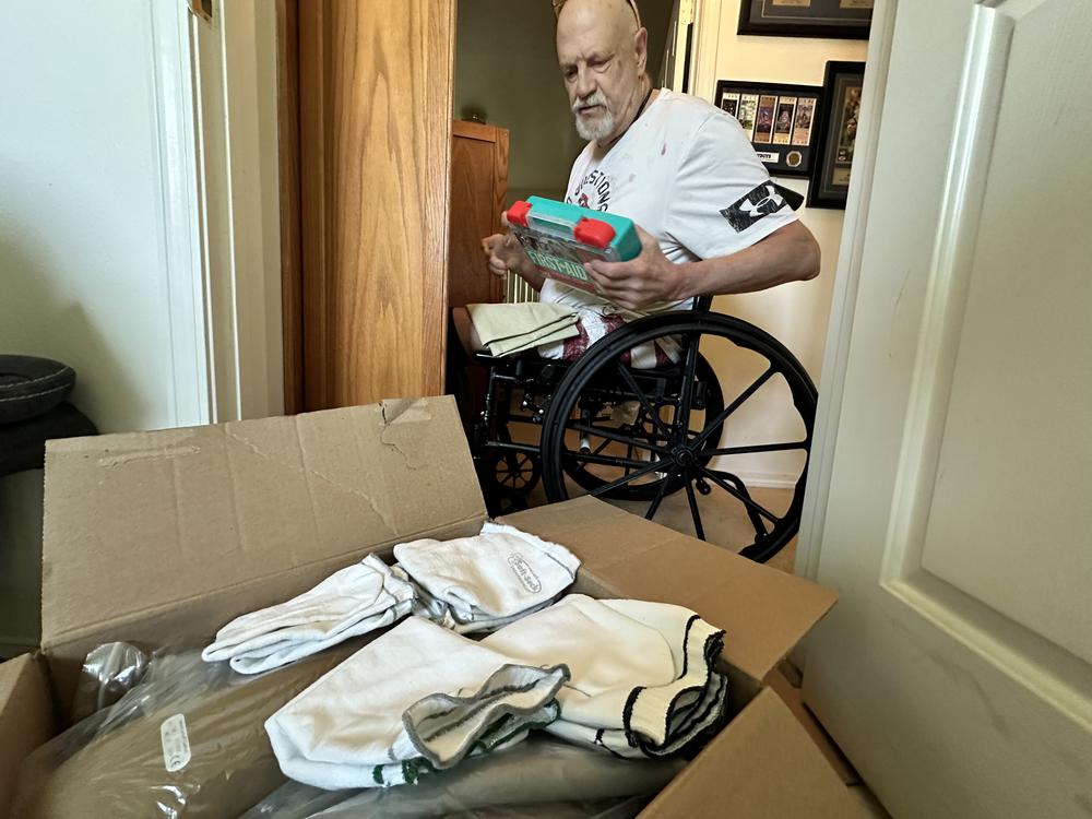 Kim Hilton boxes up his belongings on July 9, 2024, shortly after his second leg was amputated. Living independently in the apartment became difficult, and after months of waiting, he got the call that an assisted living facility that takes his Medicaid waiver had a room that would soon be available.