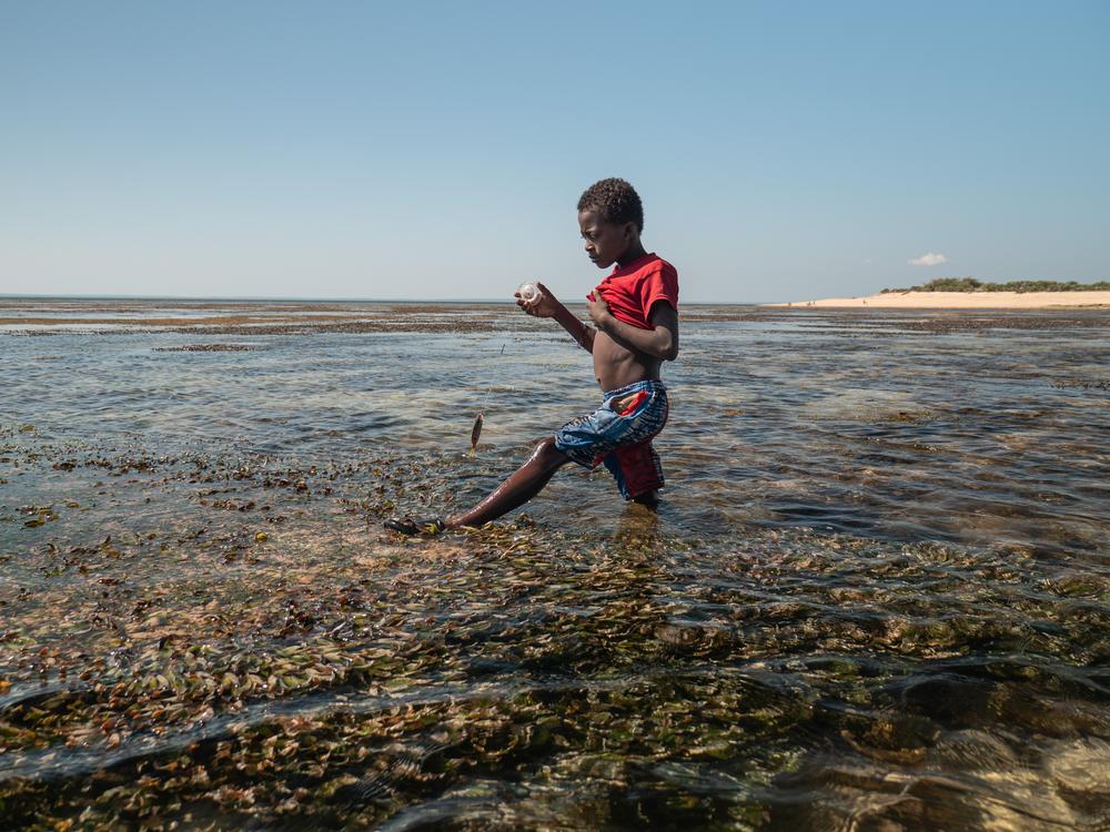 A child fishes with a string in the shallow waters of Nosy Maraontaly island, in Madagascar's Barren Isles.