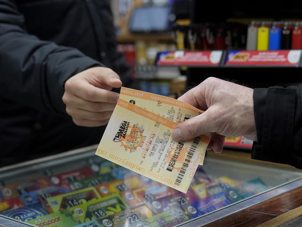 Rob, right, buys a Mega Millions ticket at Rossi's Deli in San Francisco, Thursday, Dec. 26, 2024.