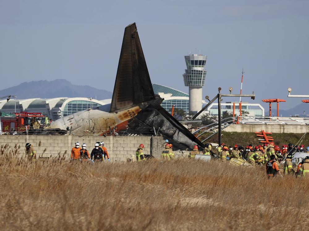 Firefighters and rescue team members work at Muan International Airport in Muan, South Korea, Sunday.