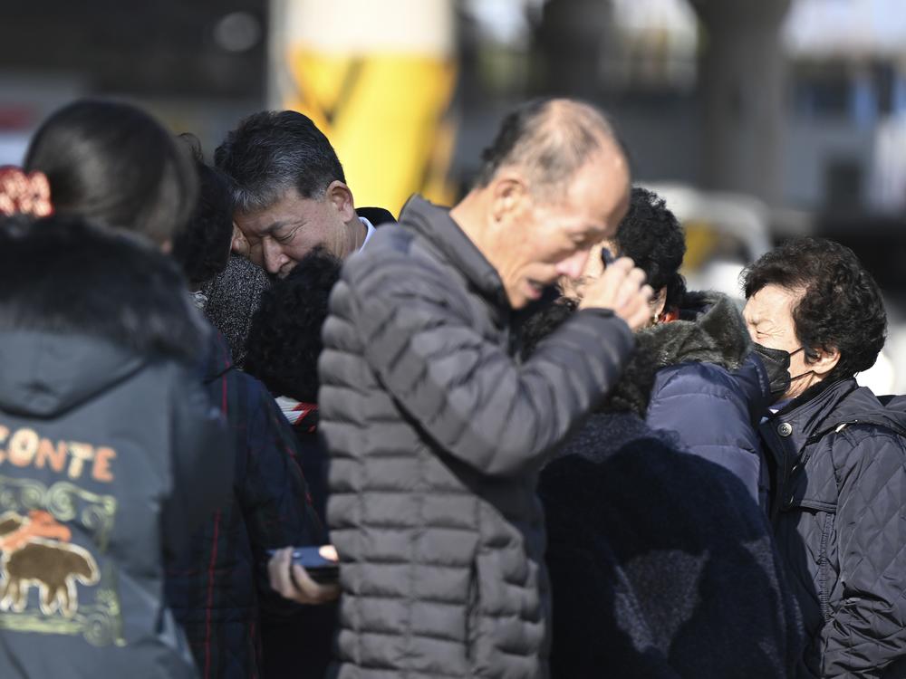 Family members of the passengers on a plane which burst into flames, weep at the Muan International Airport in Muan, South Korea, on Sunday.