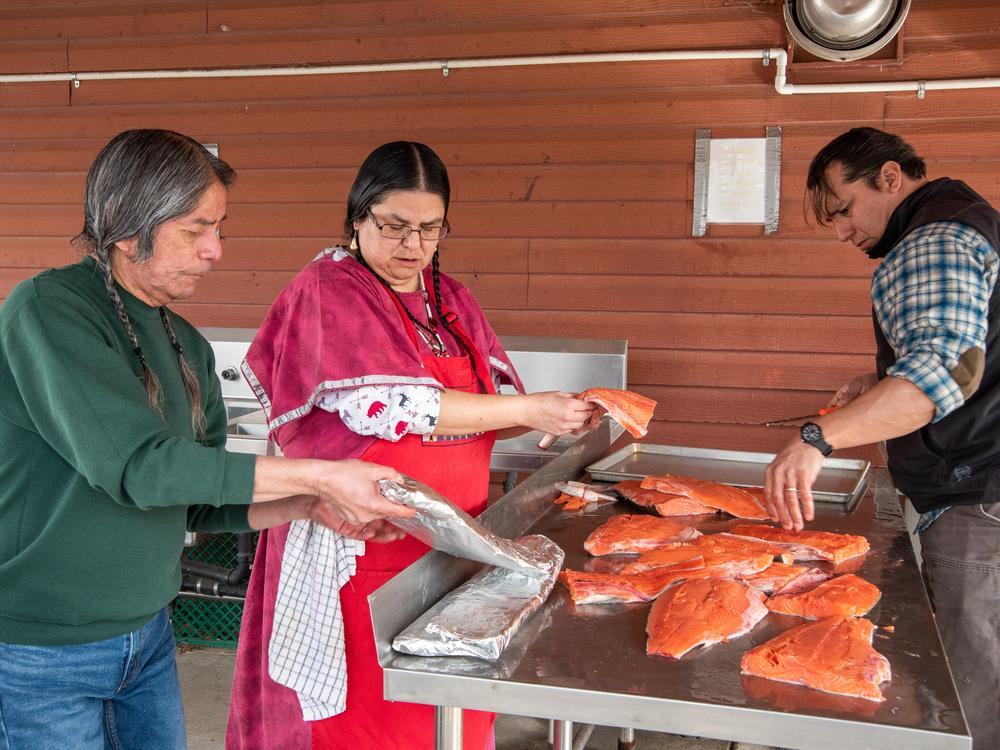 Armand Minthorn, left, LeAnn Alexander and Jeremy Wolf prepare salmon for the annual wild celery root feast March 4, 2023 at the Confederated Tribes of the Umatilla Indian Reservation (CTUIR) longhouse in Mission, Oregon.
