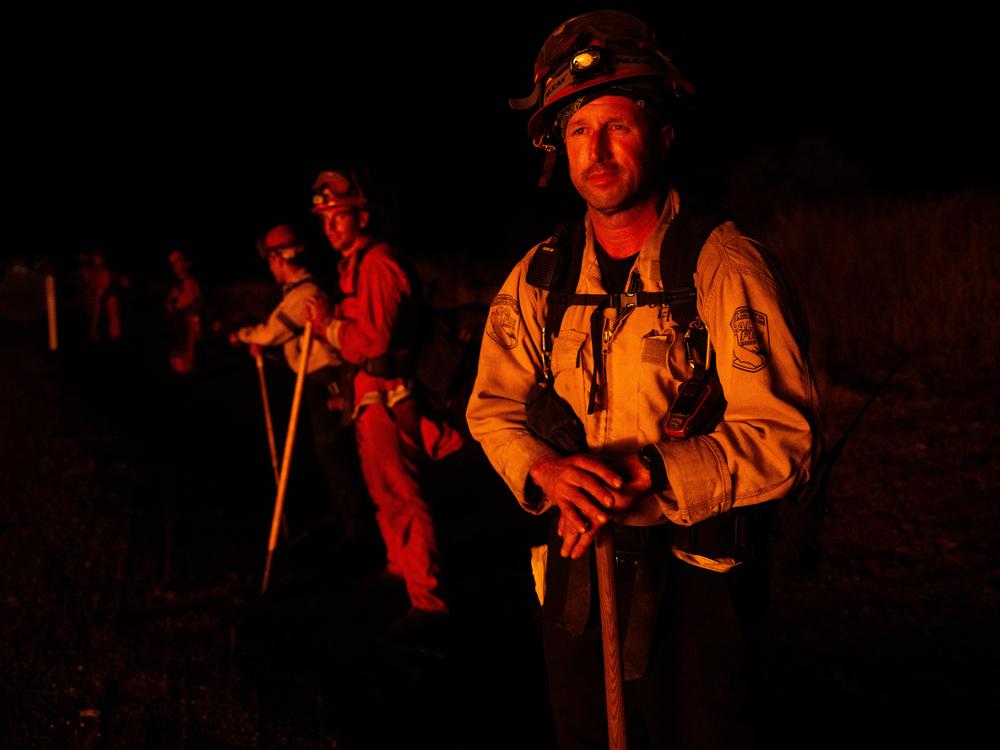 Nick Gelos, fire captain with CalFire at the Gabilan Conservation Camp, holds the fire line on Route 32 northeast of Chico along with an inmate hand crew in the early morning of July 26. Full story <a href=