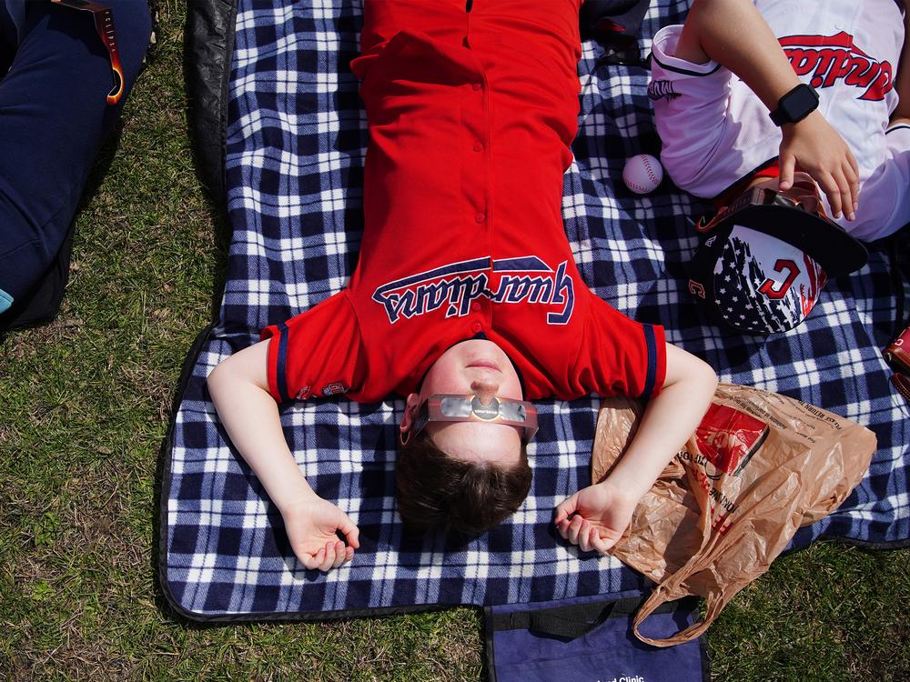 Zachary Rigelsky, 10, of Highland Heights, Ohio, lies on the ground outside of the Great Lakes Science Center in Cleveland ahead of the total solar eclipse on April 8. Full story <a href=