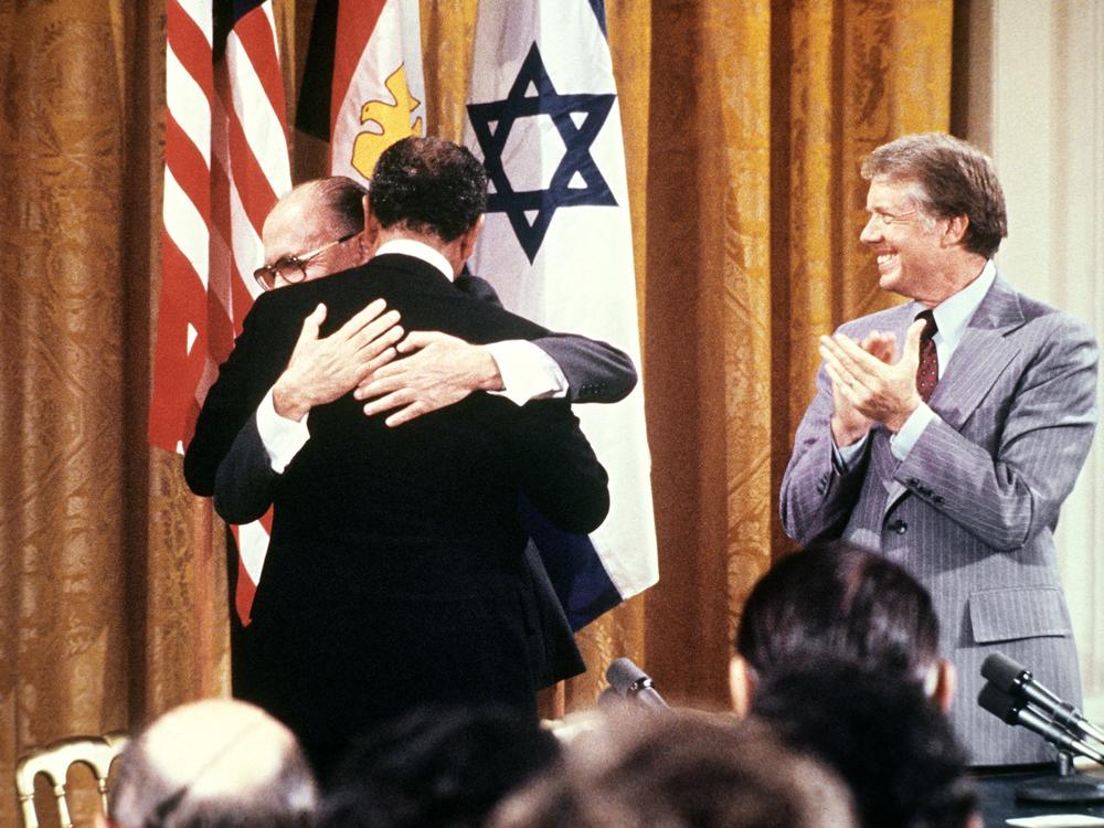 Egyptian President Anwar al-Sadat (back to camera) and Israeli Premier Menachem embrace each other, on Sept. 17, 1978, after signing a peace agreement in the White House with US President Jimmy Carter.