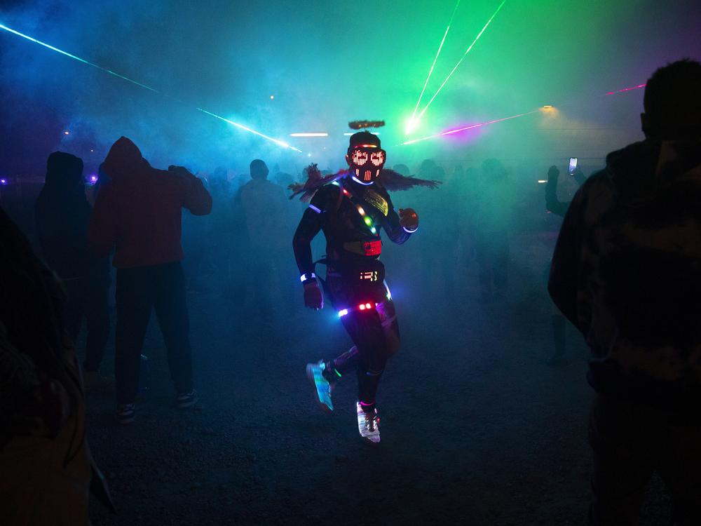 Kevin Hernandez, known as HAPPYTEARS, dances while wearing a halo and light up wings, during a renegade rave under a bridge on Oct. 11, in Seattle. Full story <a href=