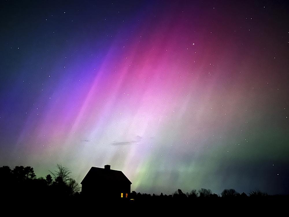 The northern lights flare in the sky over a farmhouse on May 10, 2024, in Brunswick, Maine.