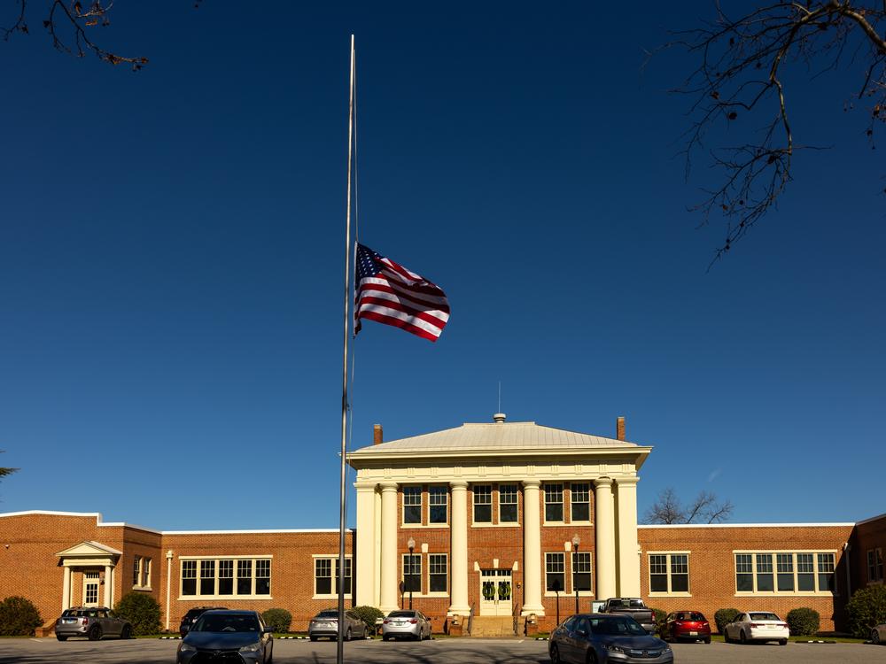 A flag flies at half-staff in front of the Plains High School visitor center on Monday. Across the United States, flags will remain lowered for the next 30 days to honor the former president.