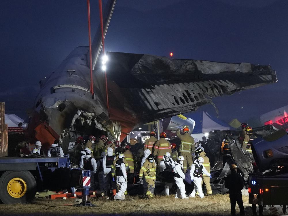 Rescue team carry the body of a passenger at the site of a plane fire at Muan International Airport in Muan, South Korea on Sunday.