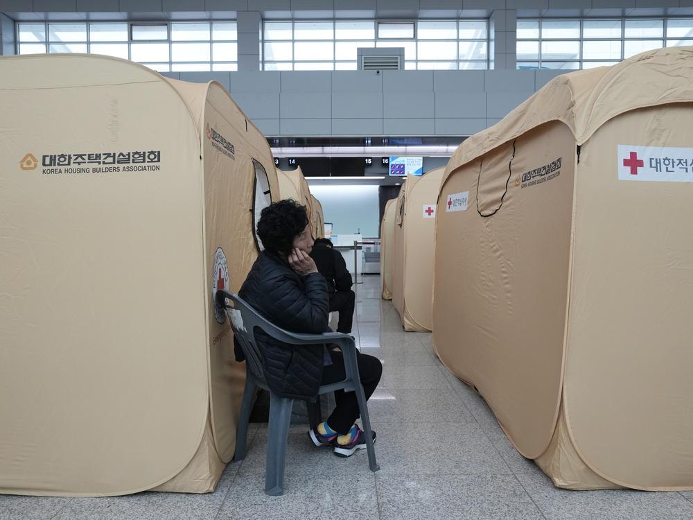 A relative of a passenger of a plane which burst into flames, reacts at a temporary shelter at Muan International Airport in Muan, South Korea on Monday.