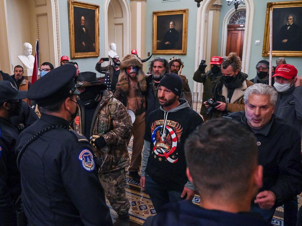 Douglas Jensen and other rioters speaking to U.S. Capitol Police in the U.S. Capitol on Jan. 6, 2021. Jensen later told the FBI he had worn the QAnon shirt and put himself at the front of the crowd because he 