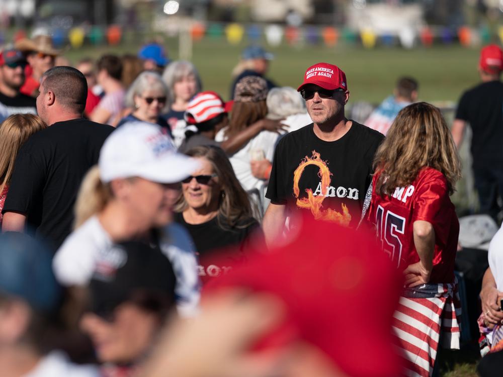 A man wearing a QAnon t-shirt walks through the crowd at a Trump rally on Sept. 25, 2021 in Perry, Ga. The nonprofit PRRI, which conducts polls on religion, found that 19% of Americans believe in the core theories associated with QAnon, up from 14% in 2021. The poll found the number rose to 32% among Republicans who support Trump.<br>