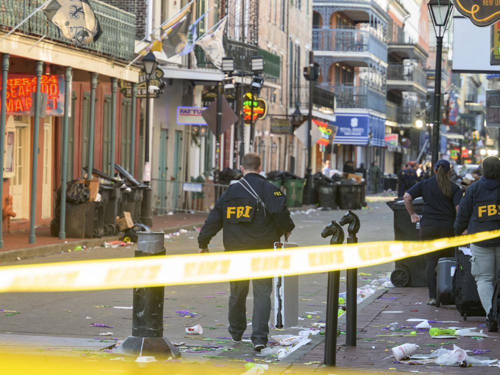 FBI investigators arrive at the scene where the white Ford F-150 pickup truck that crashed into a work lift after allegedly driving into a crowd of New Year's revelers in the French Quarter of New Orleans.