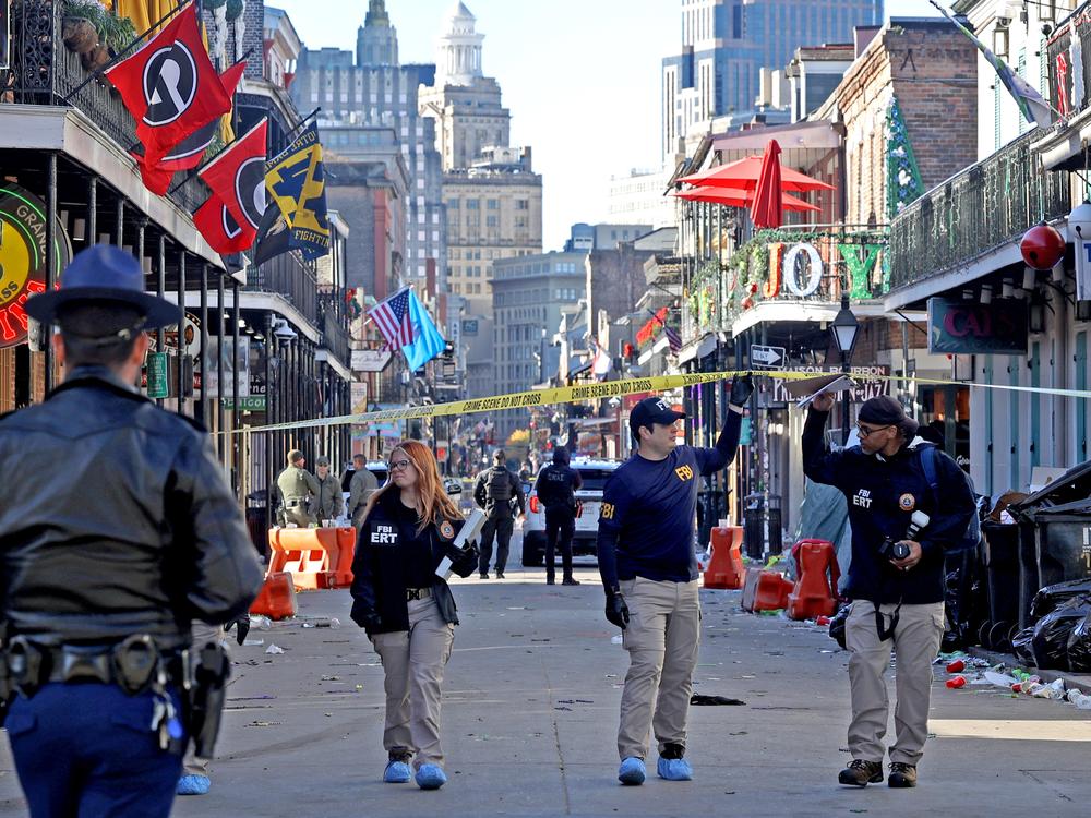 Law enforcement officers from multiple agencies work the scene on Bourbon Street.