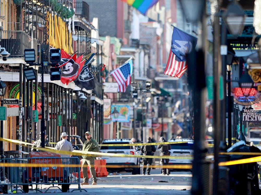 Law enforcement officers from multiple agencies work the scene on Bourbon Street.