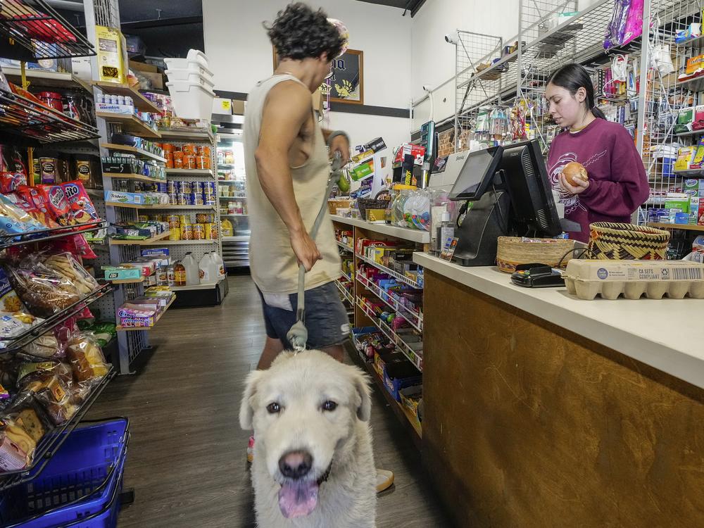College student Jimena Sanchez (right), who studies children's development, works as a part-time cashier earning minimum wage at a family store in Los Angeles on Oct. 11.