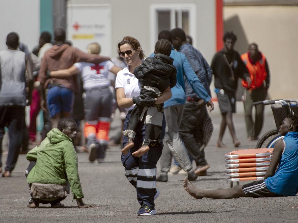 A member of the emergency services carries a little child, part of a group of 175 migrant people who arrived on board a boat, at Restinga port on the Canary island of El Hierro on August 18, 2024.