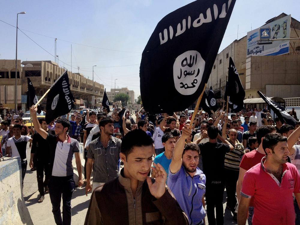 Demonstrators chant pro-Islamic State group slogans as they carry the group's flags in front of the provincial government headquarters in Mosul, Iraq, on June 16, 2014.