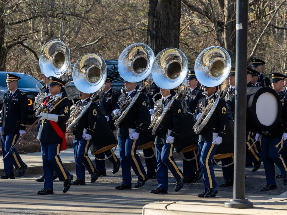 Military band members play during a ceremony for the arrival of the casket of former U.S. President Jimmy Carter at the Carter Center.