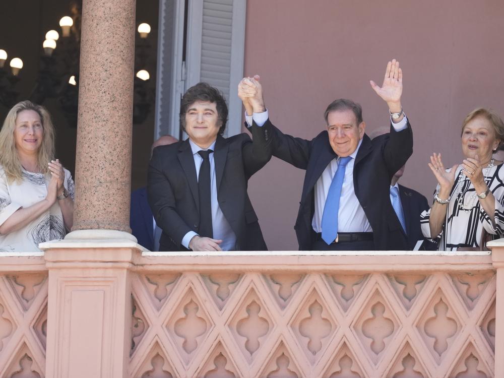 Venezuela's opposition leader Edmundo Gonzalez Urrutia, center right, and Argentine President Javier Milei hold hands from the government house balcony in Buenos Aires, Argentina, Saturday, Jan. 4, 2025.