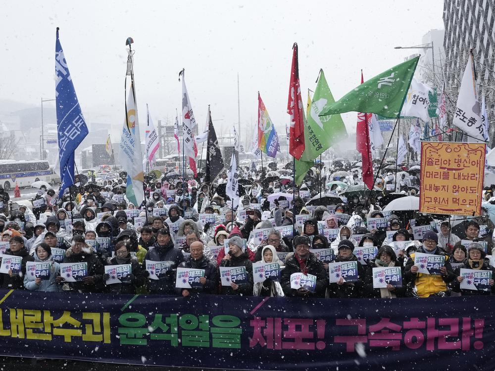 Protesters stage a rally demanding the arrest of impeached South Korean President Yoon Suk Yeol near the presidential residence in Seoul, South Korea, on Sunday. The letters read 