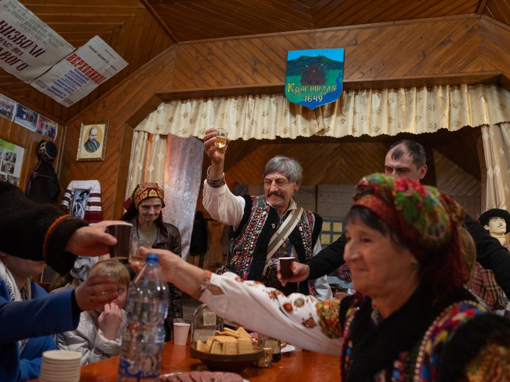 After a rehearsal, members of the Hutsul Theater troupe have drinks and share some meats and cheeses together on Nov. 3 in Krasnoillya, Ukraine. <a href=