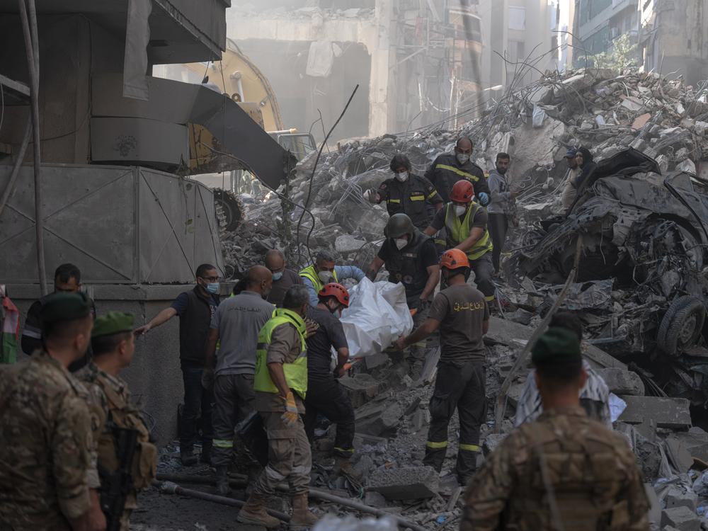 Search-and-rescue teams carry a body recovered from the rubble at the site of an Israeli strike in a central Beirut neighborhood, Nov. 23.