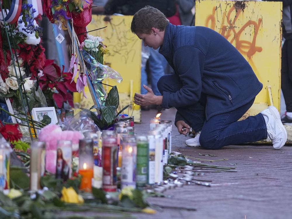 Nathan Williams, a University of New Orleans student, lights a candle at a memorial on Bourbon Street on Friday for the victims of a deadly truck attack on New Year's Day in New Orleans.