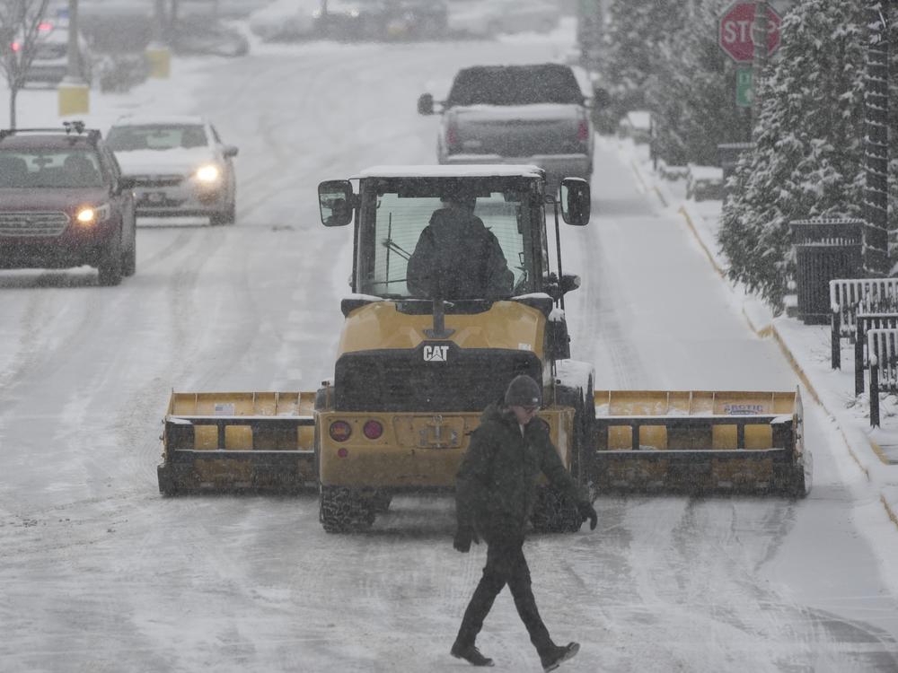 A plow clears a parking lot during a winter storm on Sunday in Cincinnati.