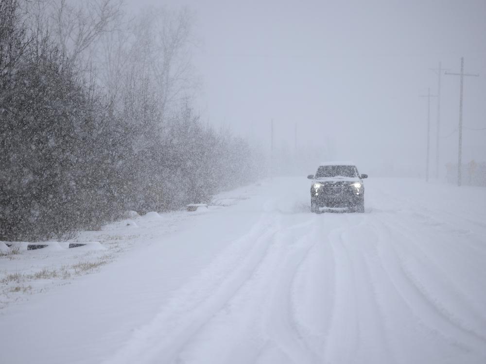 A motorist drives through the snow near Louisville Muhammad Ali International Airport on Sunday in Louisville, Ky. Local forecasts called for heavy snowfall followed by significant accumulation of freezing rain and ice.